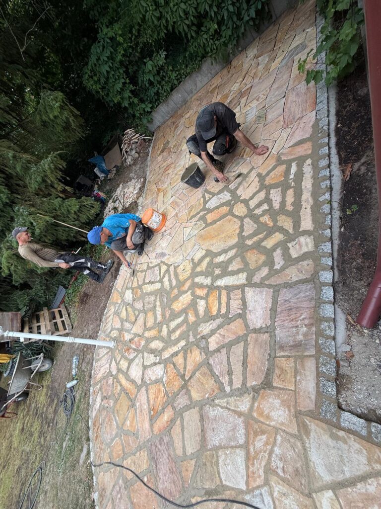 ISAC-Team beim Verfugen der Polygonalplatten, Kleinmachnow