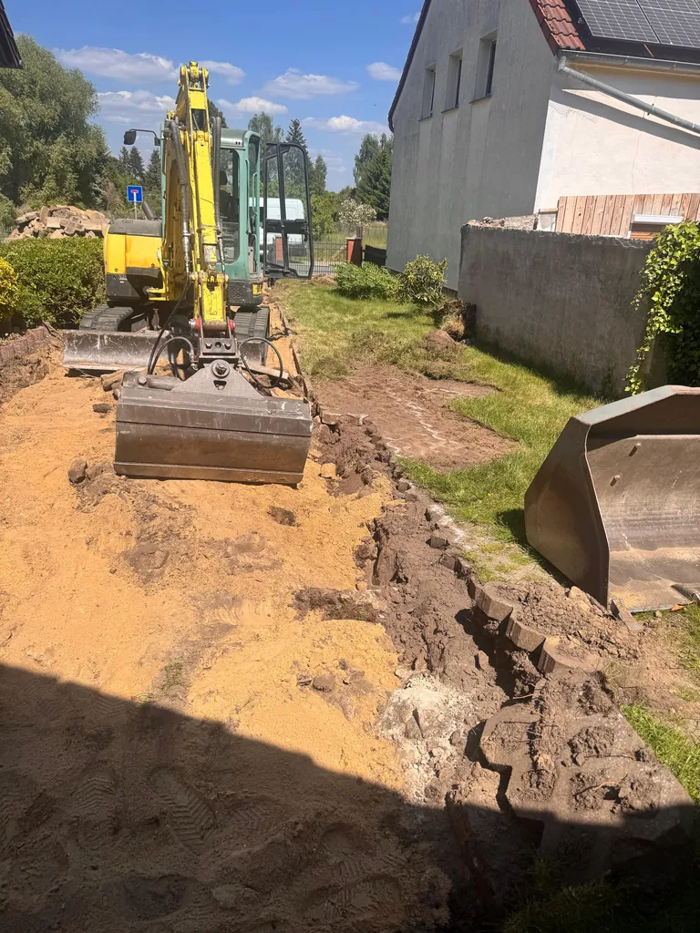Minibagger beim Aushub am seitlichen Grundstücksrand