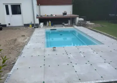 Frisch verlegte Plattenumrandung am Pool mit Rasenanschluss